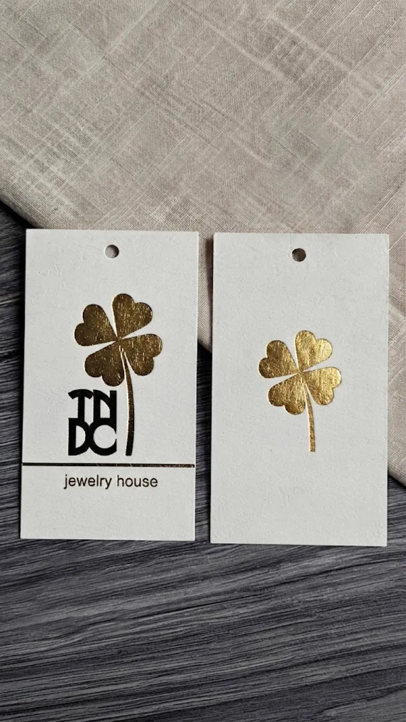 Білі бірки TNDC jewelry house із золотою конюшиною